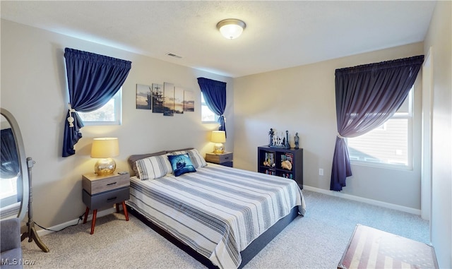 bedroom with carpet floors and multiple windows