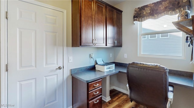 home office featuring hardwood / wood-style floors and built in desk