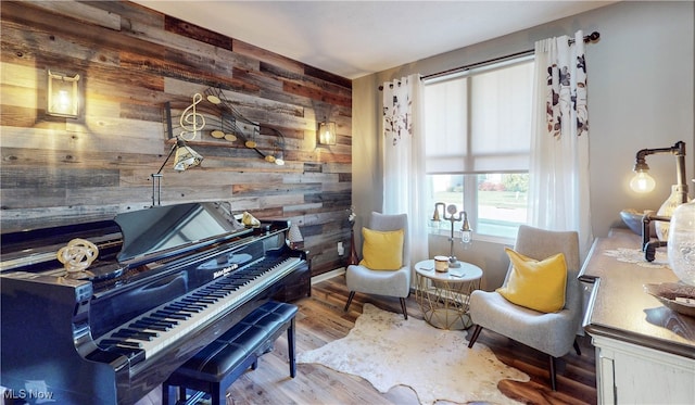 sitting room featuring hardwood / wood-style flooring and wooden walls