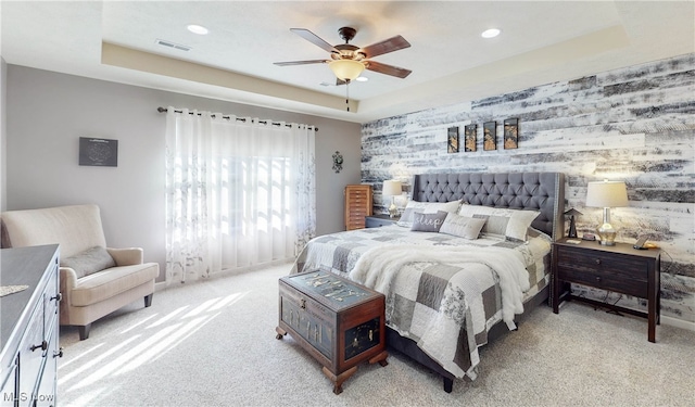 bedroom with a tray ceiling, ceiling fan, and light colored carpet