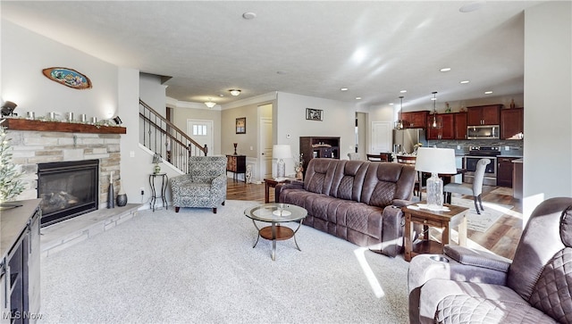 carpeted living room with a stone fireplace