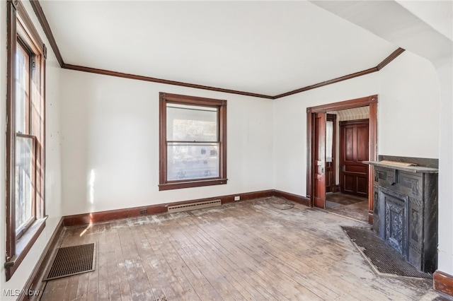 unfurnished living room featuring hardwood / wood-style flooring, a wealth of natural light, and crown molding