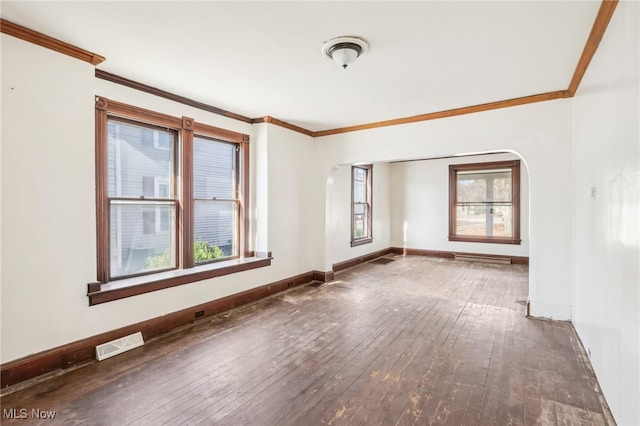 spare room with hardwood / wood-style floors, plenty of natural light, and ornamental molding