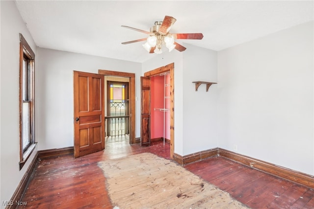 unfurnished bedroom with ceiling fan, a closet, and dark wood-type flooring