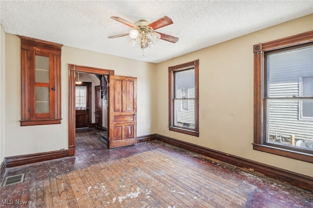 spare room with ceiling fan, dark hardwood / wood-style flooring, and a textured ceiling