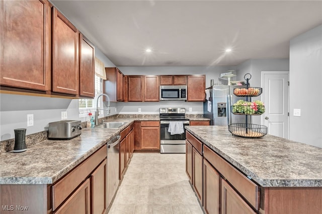 kitchen with stainless steel appliances, a kitchen island, and sink