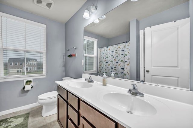 bathroom with tile patterned floors, a shower with curtain, vanity, and toilet