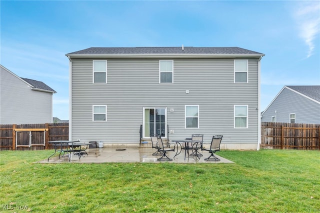 rear view of property featuring a lawn and a patio