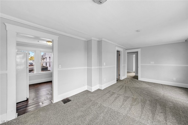 unfurnished living room with crown molding, baseboards, visible vents, and carpet