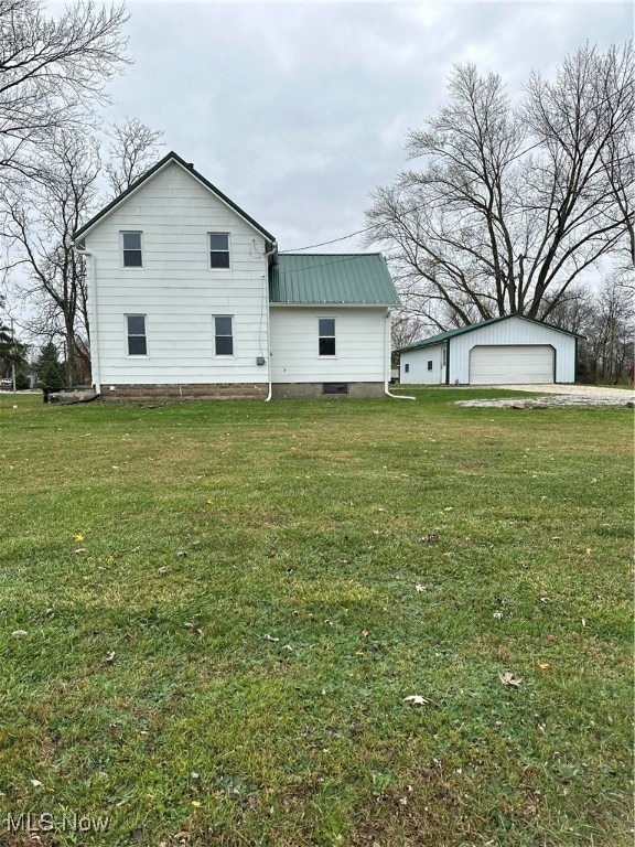 view of home's exterior with an outbuilding, a yard, and a garage