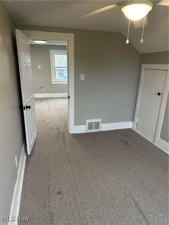 carpeted empty room featuring vaulted ceiling and ceiling fan