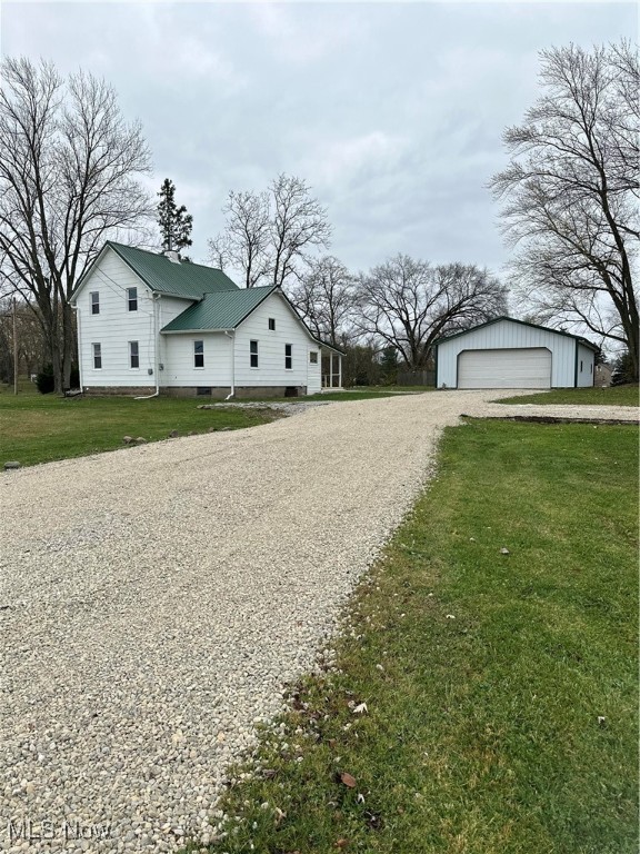 exterior space with a garage, an outdoor structure, and a yard