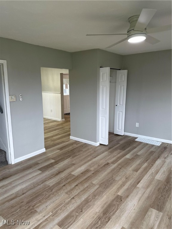 spare room featuring light wood-type flooring and ceiling fan