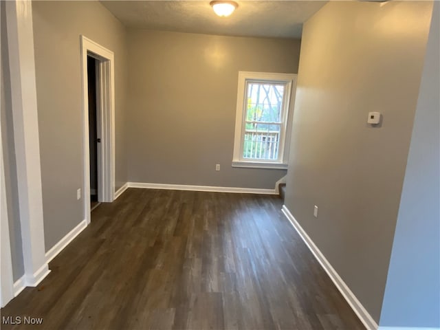 empty room with dark wood-type flooring