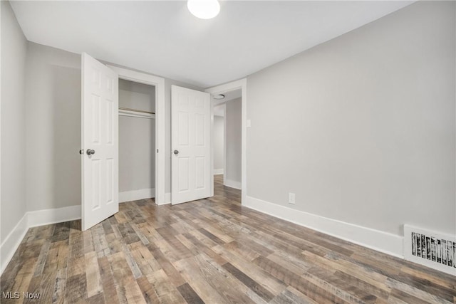 unfurnished bedroom with hardwood / wood-style floors and a closet