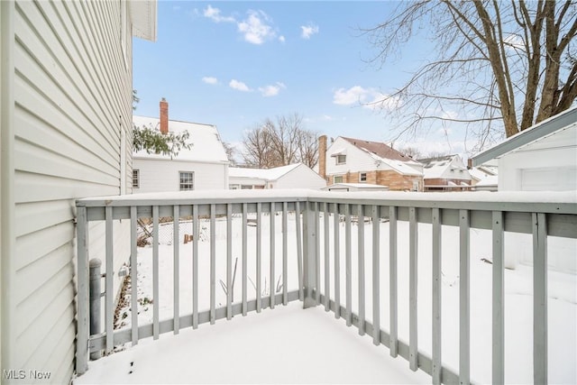 view of snow covered back of property