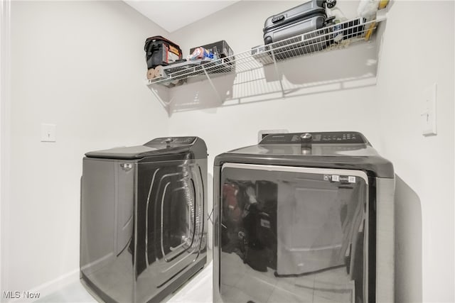 clothes washing area with washing machine and dryer