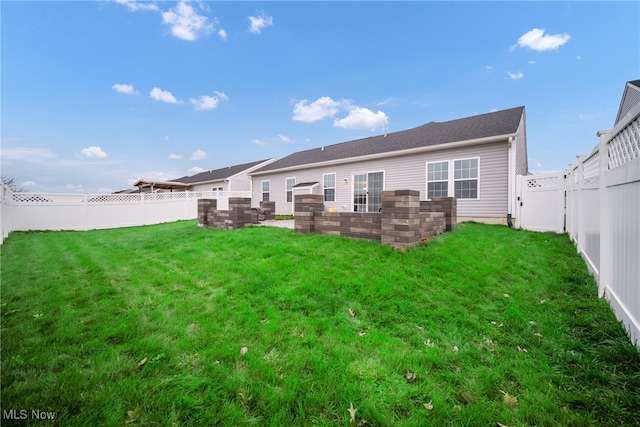 rear view of property featuring a yard