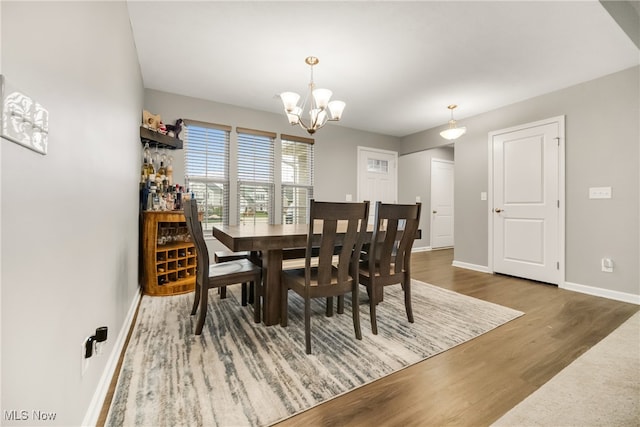 dining area featuring a notable chandelier and dark wood-type flooring