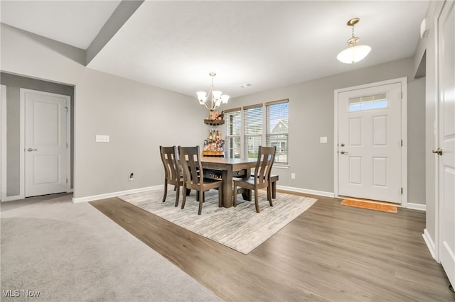 dining room with hardwood / wood-style floors and a notable chandelier