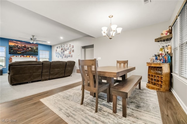 dining room featuring hardwood / wood-style flooring and ceiling fan with notable chandelier