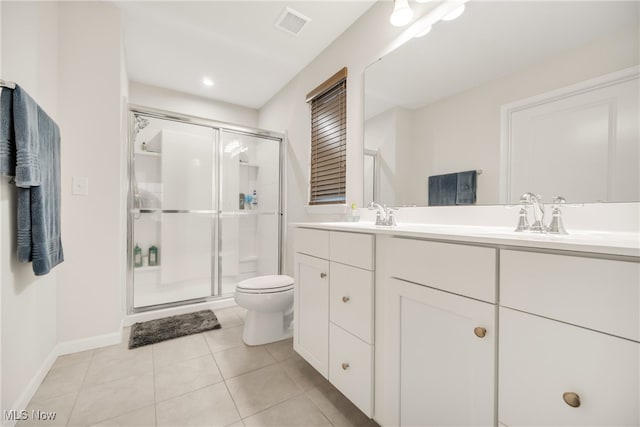 bathroom featuring tile patterned flooring, vanity, a shower with door, and toilet