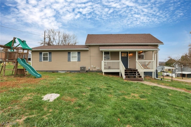 view of front facade with a playground, cooling unit, covered porch, and a front yard