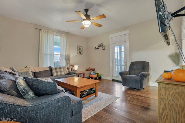 living room with dark hardwood / wood-style flooring and ceiling fan