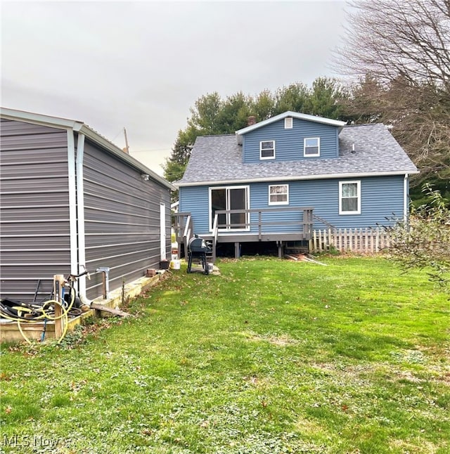 rear view of property with a lawn and a wooden deck