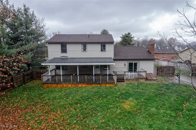 rear view of house featuring a yard and a deck