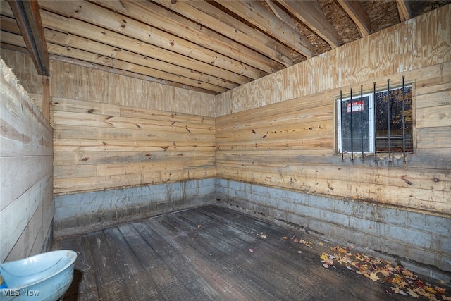 empty room featuring hardwood / wood-style floors and wooden walls