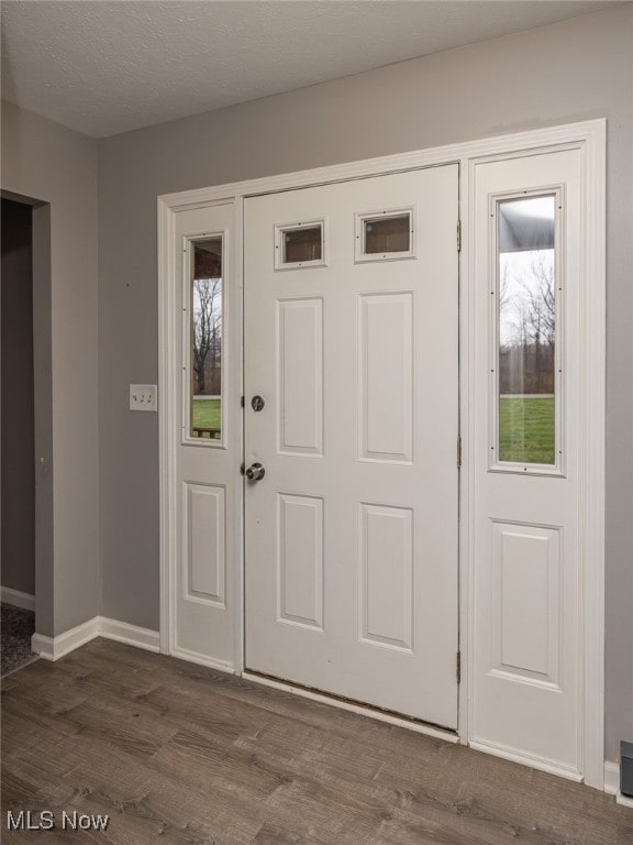 entryway featuring a textured ceiling and dark wood-type flooring