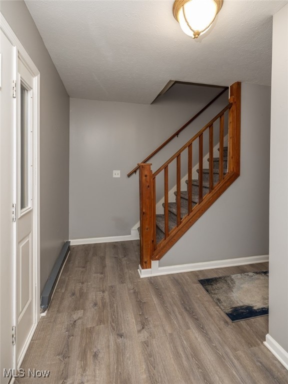 stairway featuring hardwood / wood-style floors and a textured ceiling