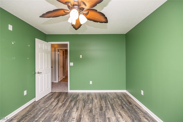 empty room featuring a textured ceiling, dark hardwood / wood-style flooring, and ceiling fan