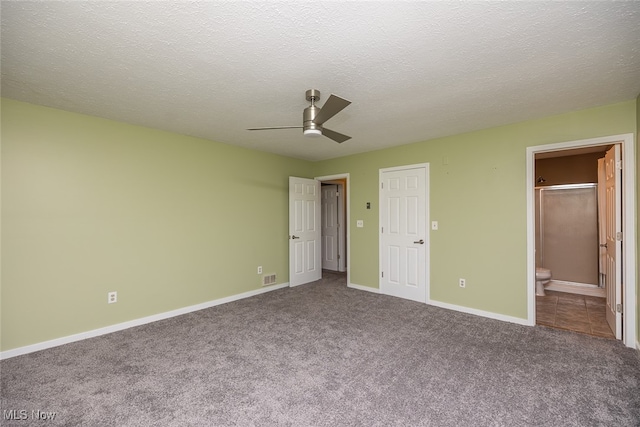 unfurnished bedroom with carpet, a textured ceiling, connected bathroom, and ceiling fan