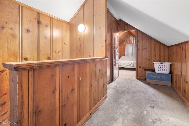 hall with vaulted ceiling and wooden walls