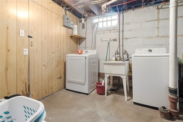 laundry room featuring wooden walls and washer and dryer