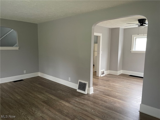 spare room with a textured ceiling, dark hardwood / wood-style floors, and ceiling fan