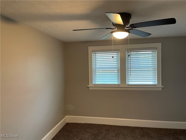 carpeted empty room featuring ceiling fan and a textured ceiling