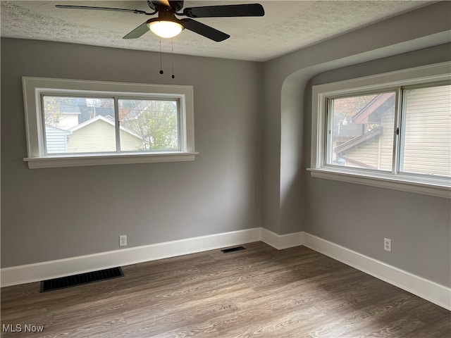 empty room with ceiling fan, a textured ceiling, and hardwood / wood-style flooring