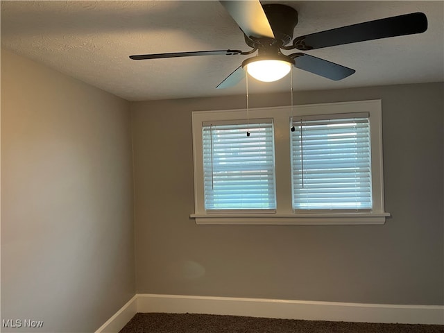 carpeted spare room featuring ceiling fan and a textured ceiling