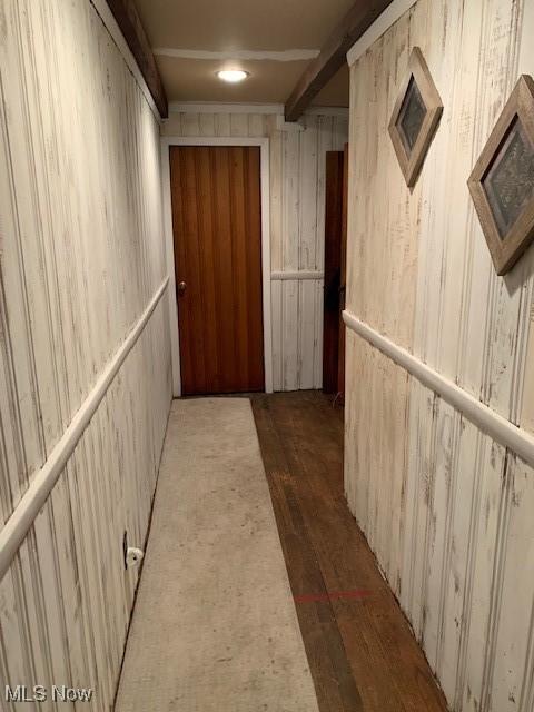 hall with beamed ceiling and dark wood-type flooring