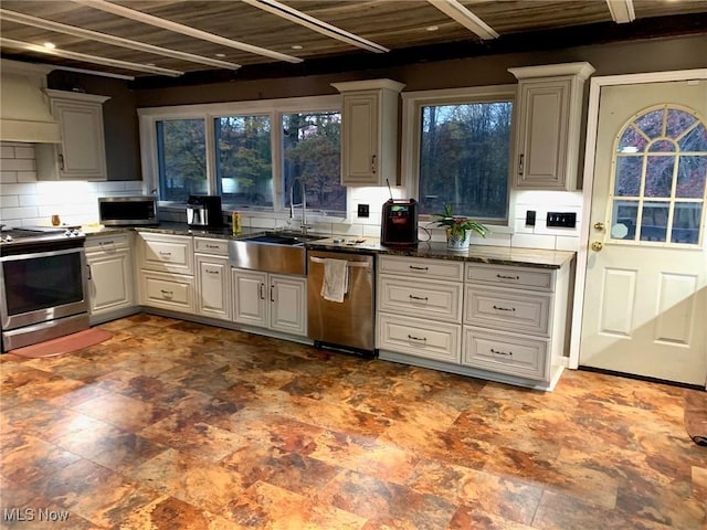 kitchen featuring stainless steel appliances, sink, wooden ceiling, custom exhaust hood, and backsplash