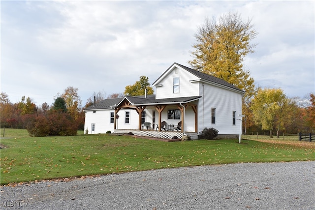 view of front of property featuring covered porch and a front yard