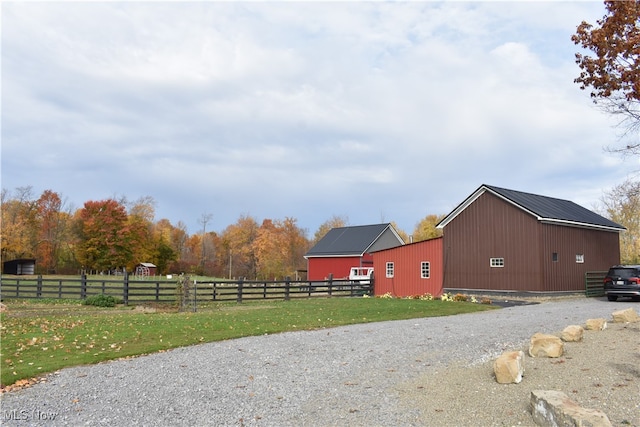 view of home's exterior with a lawn and an outdoor structure