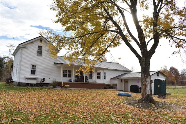 rear view of house with a storage unit and a wooden deck