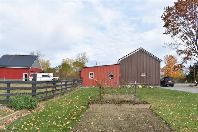 view of side of home with a lawn and an outdoor structure