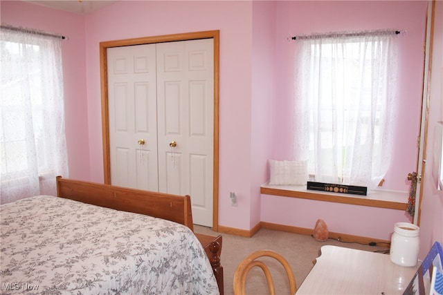 bedroom with light carpet and a closet