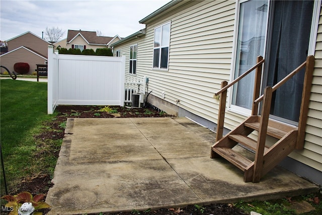 view of side of property featuring a lawn, cooling unit, and a patio