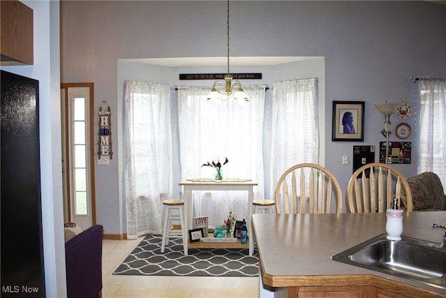 tiled dining area featuring plenty of natural light, a notable chandelier, and sink